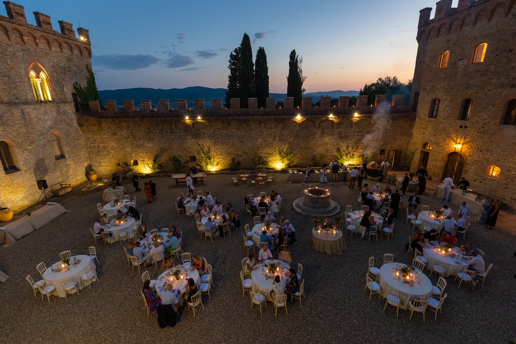 A courtyard event inside an old stone castle at dusk
