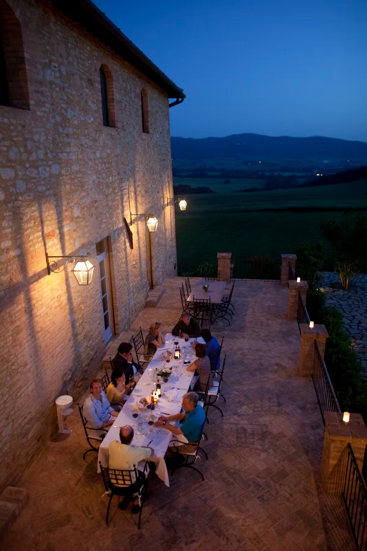 a stone building that has a clock at the top of a brick wall