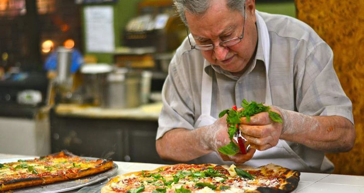 a man holding a slice of pizza