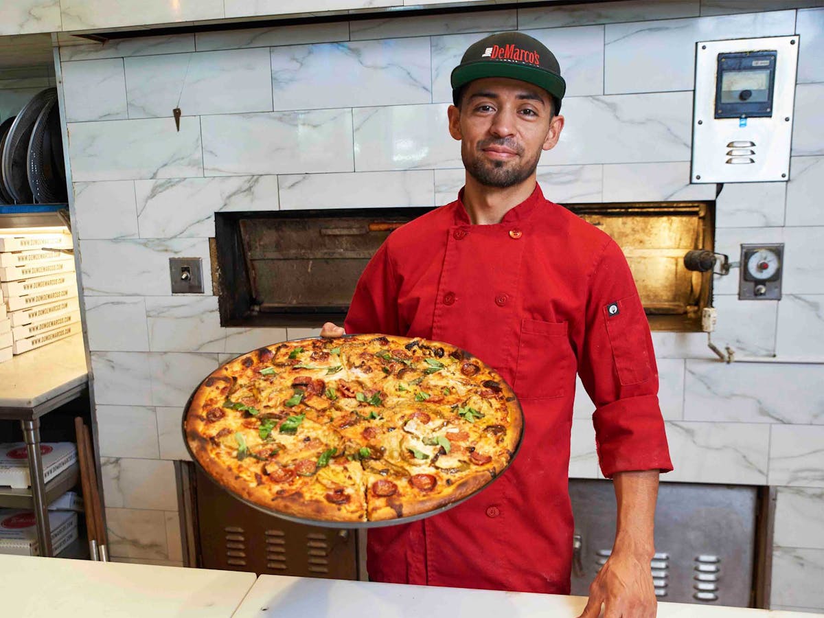 a man holding a pizza