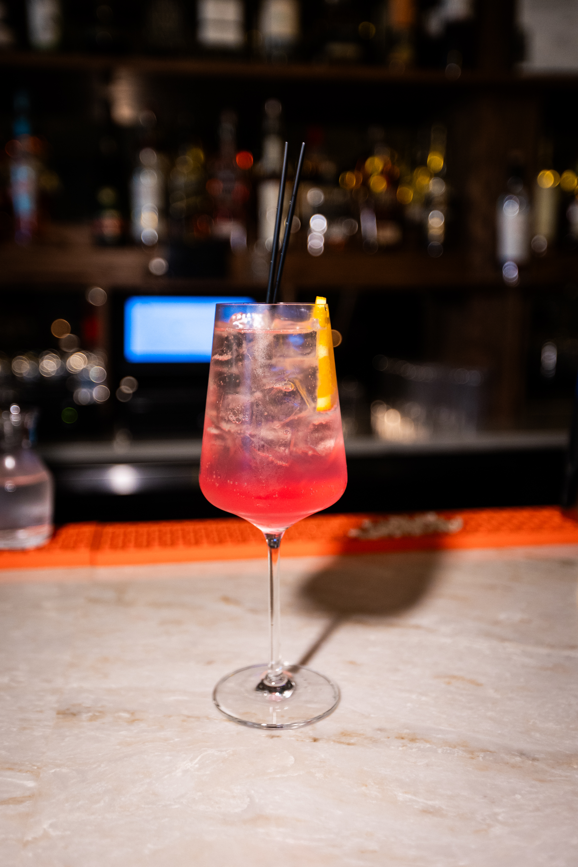 a glass of pink drink with a straw