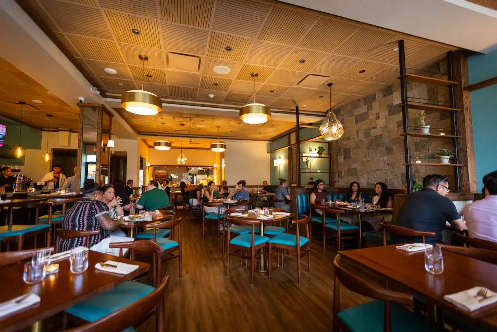 a group of people sitting at tables in a restaurant