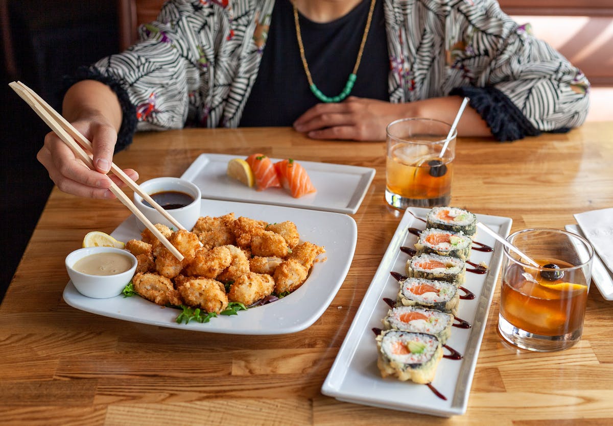 a person sitting at a table with a plate of food