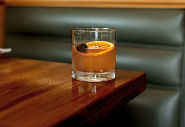 a glass of orange juice on a wooden table