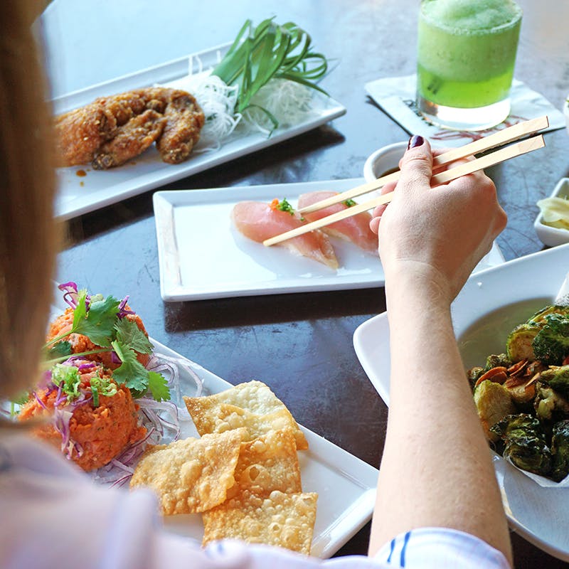 a person sitting at a table with a plate of food