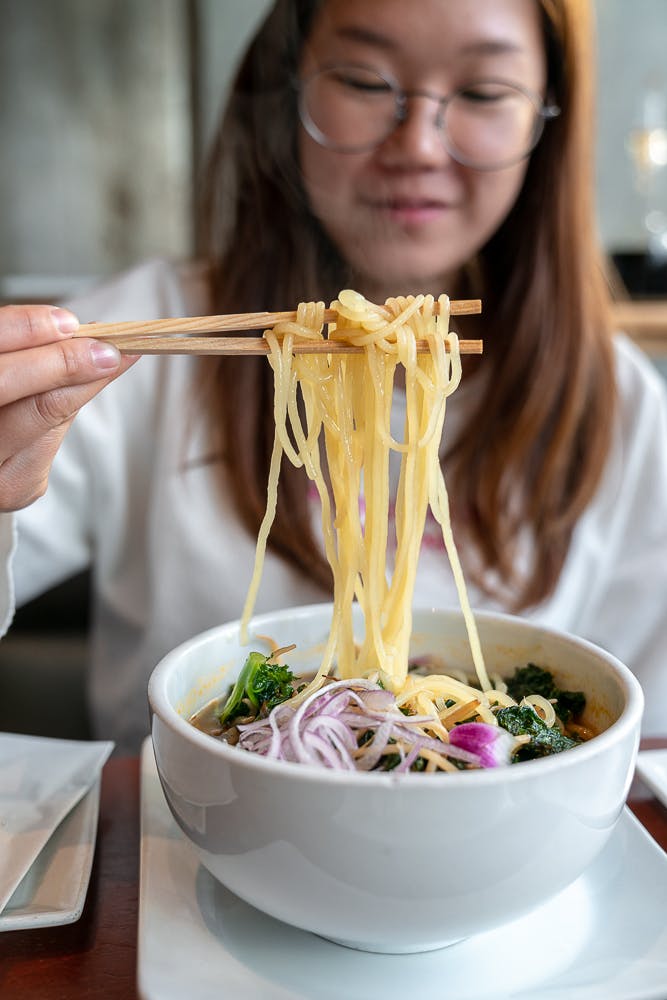 a woman sitting at a table with a plate of food