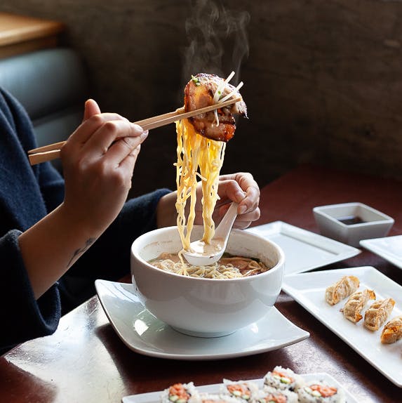 a person sitting at a table eating food