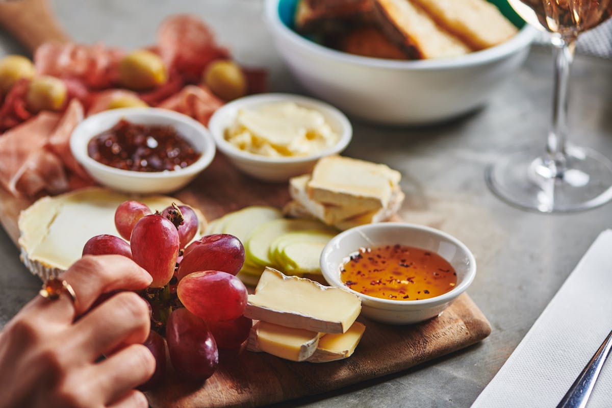 a table topped with cheese and grapes on a plate