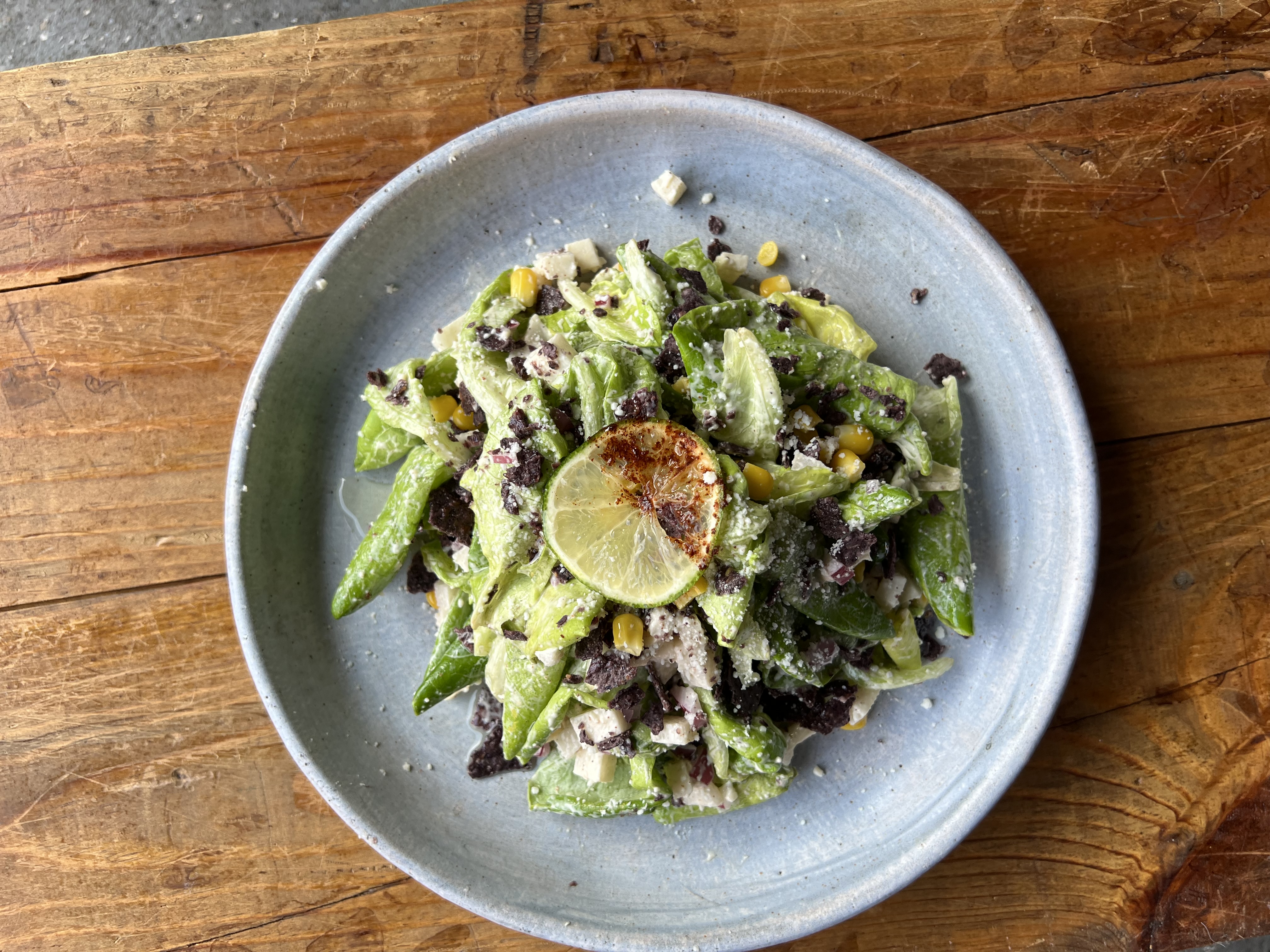 a bowl of food sitting on top of a wooden table