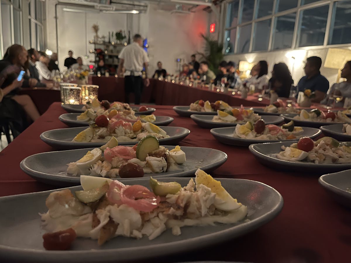 a group of people sitting at a table with a plate of food