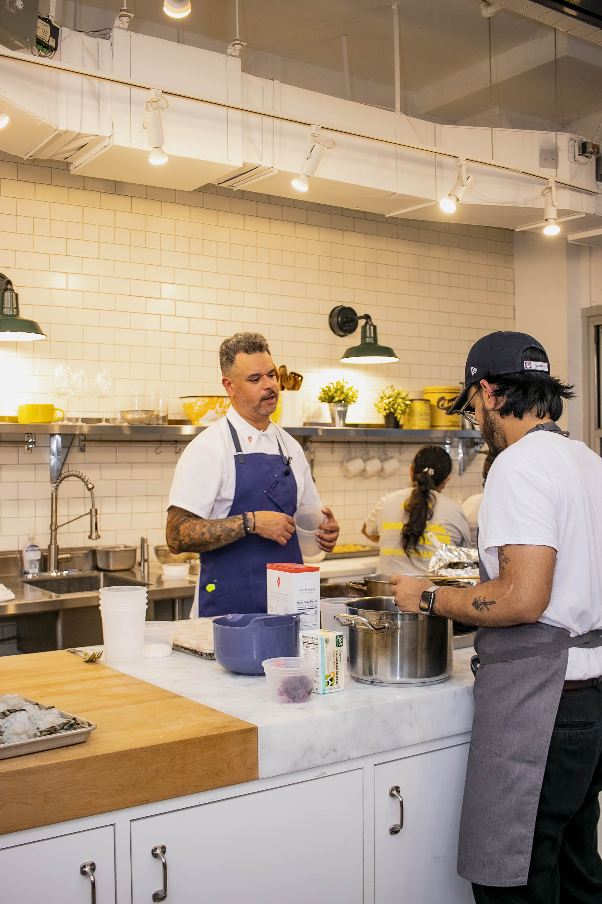 a group of people standing in a kitchen preparing food