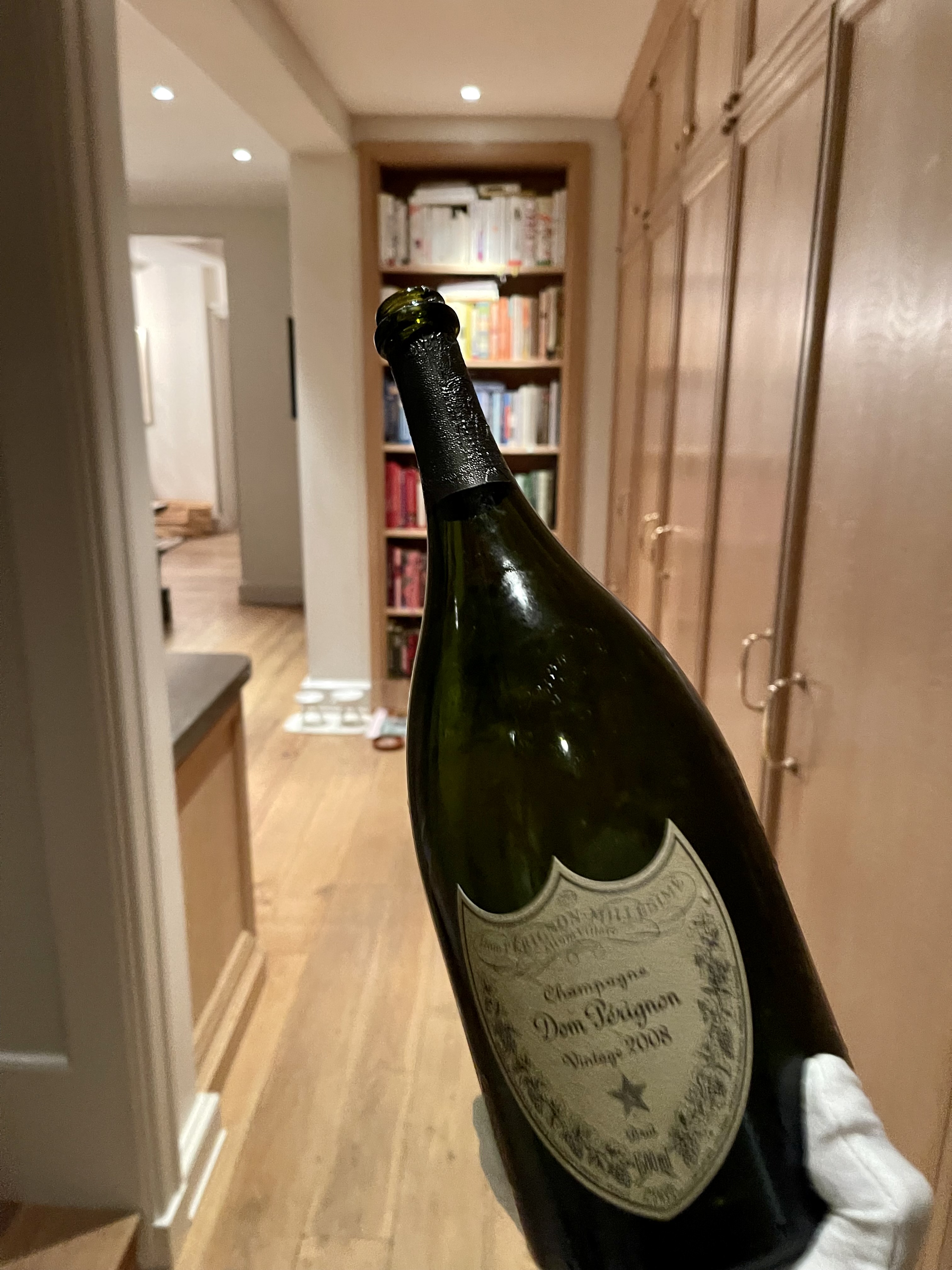 a bottle with a liquid in front of a mirror posing for the camera