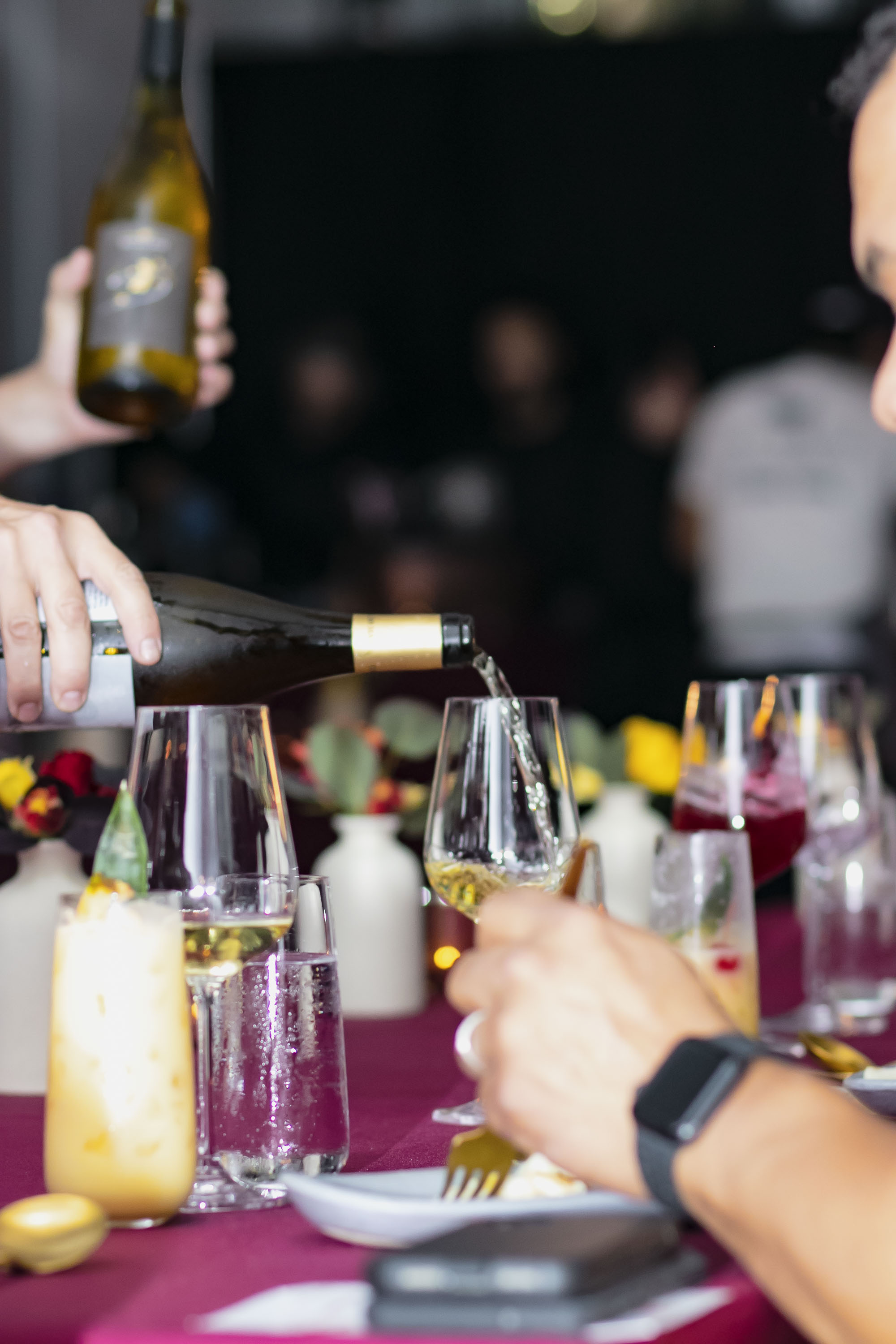 a person holding a bottle of wine on a table
