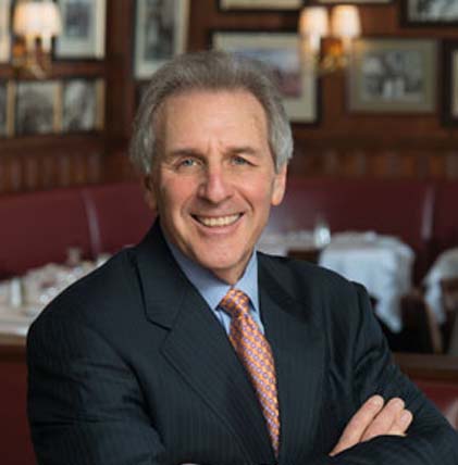 a man posing and wearing a tuxedo