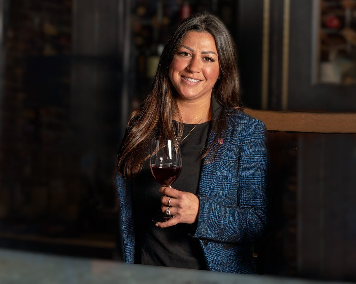 a woman holding a wine glass posing for the camera