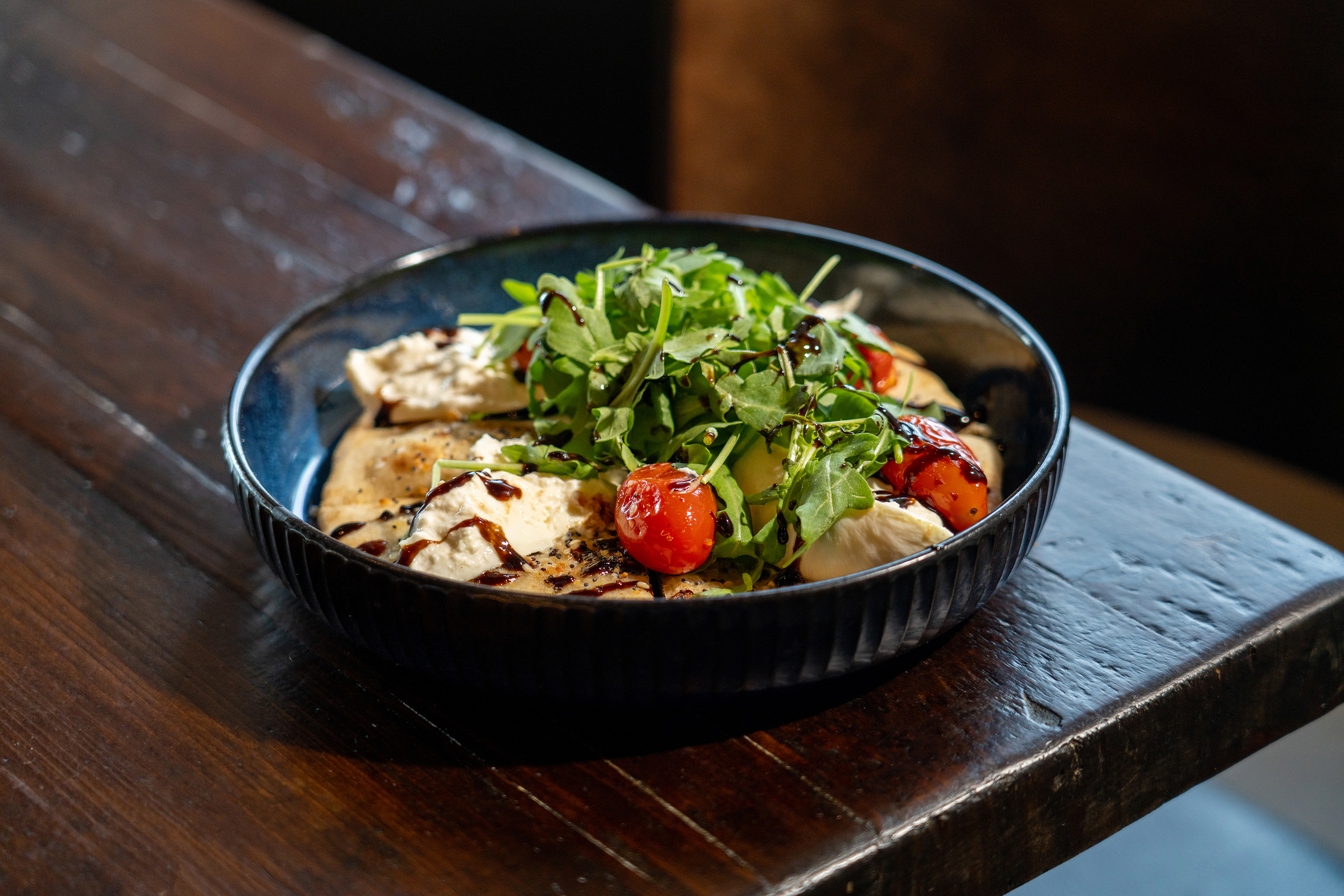 a bowl of food sitting on top of a wooden table