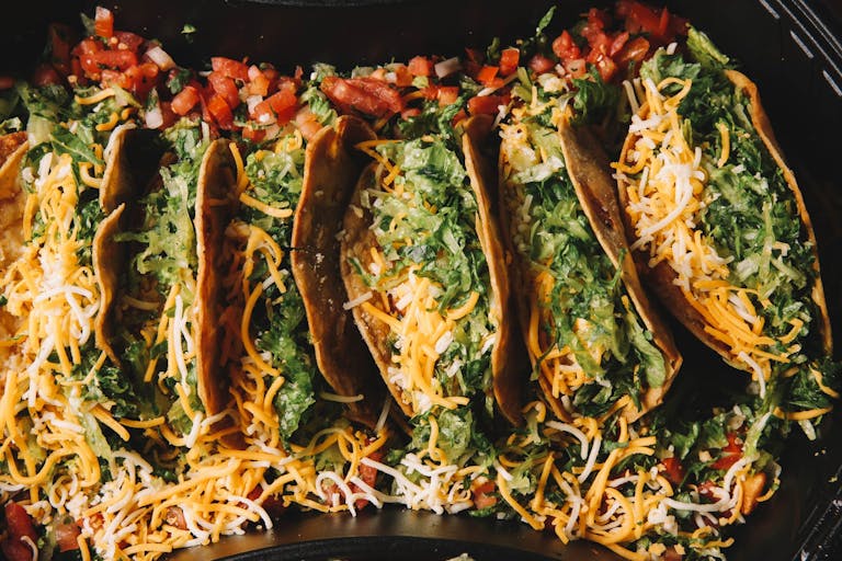 a pan filled with 10 hard shell folded tacos