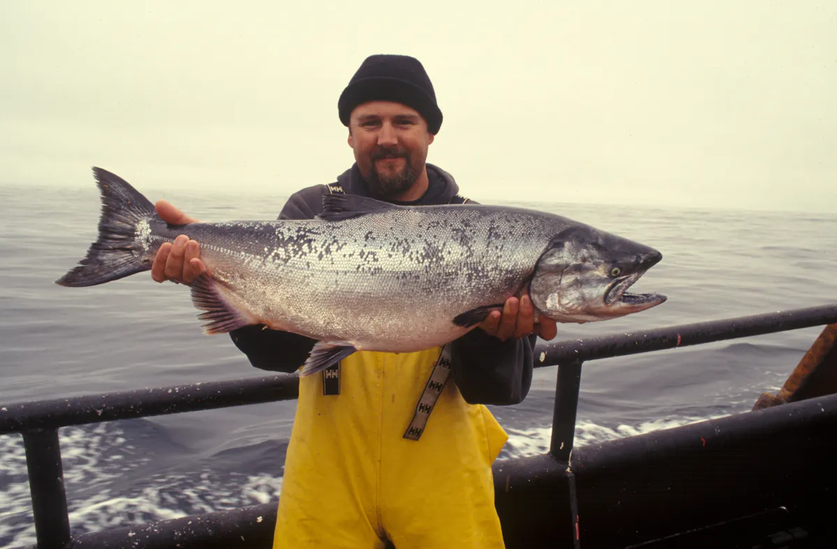 a man holding a fish in the water