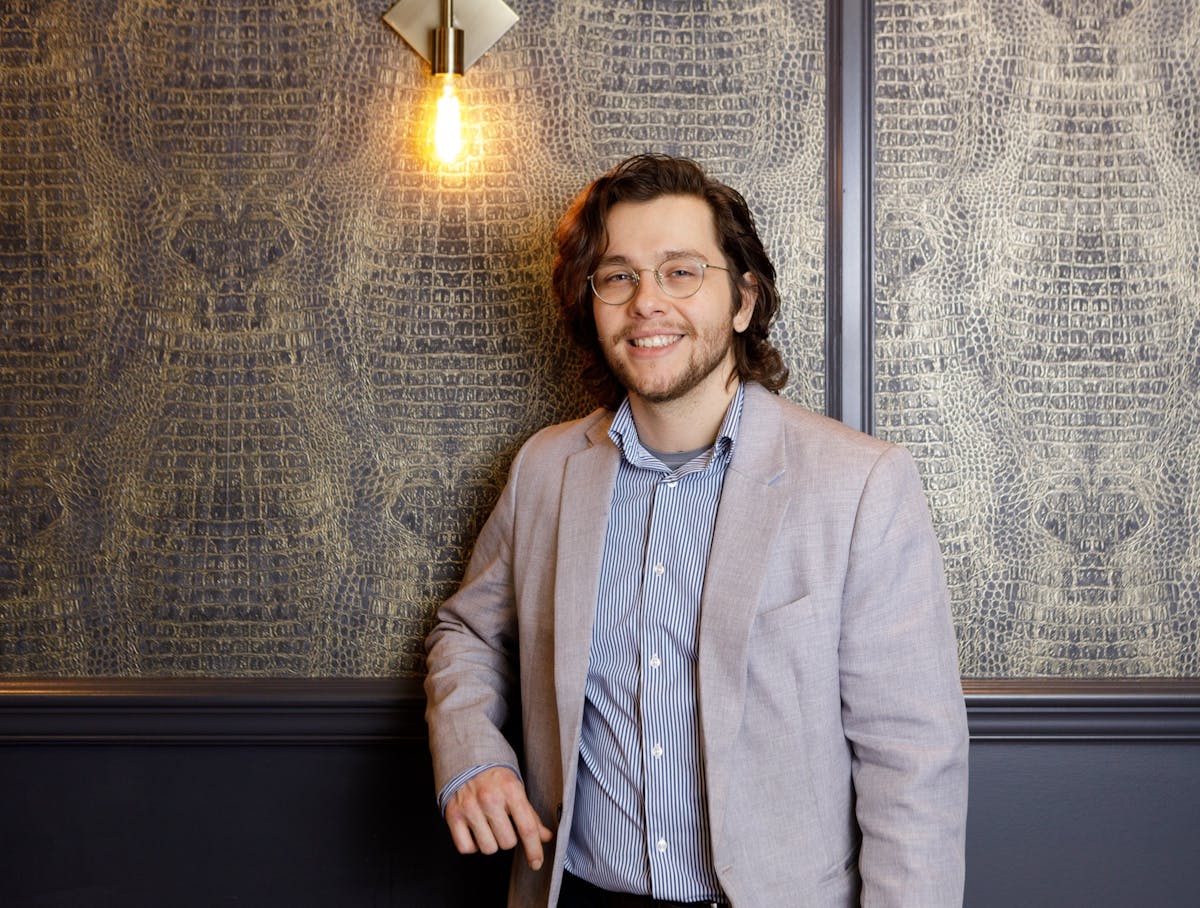 a man standing in front of a window posing for the camera