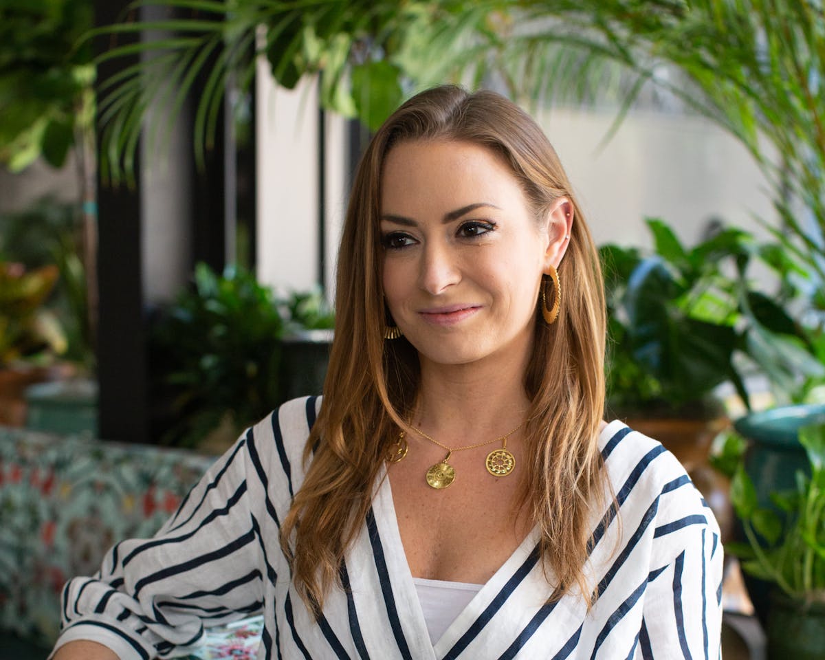 a woman in a striped shirt and smiling at the camera