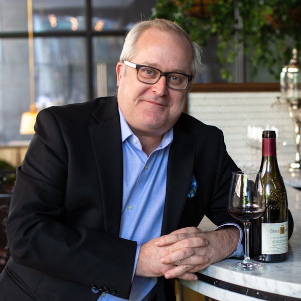 a man sitting at a table with wine glasses