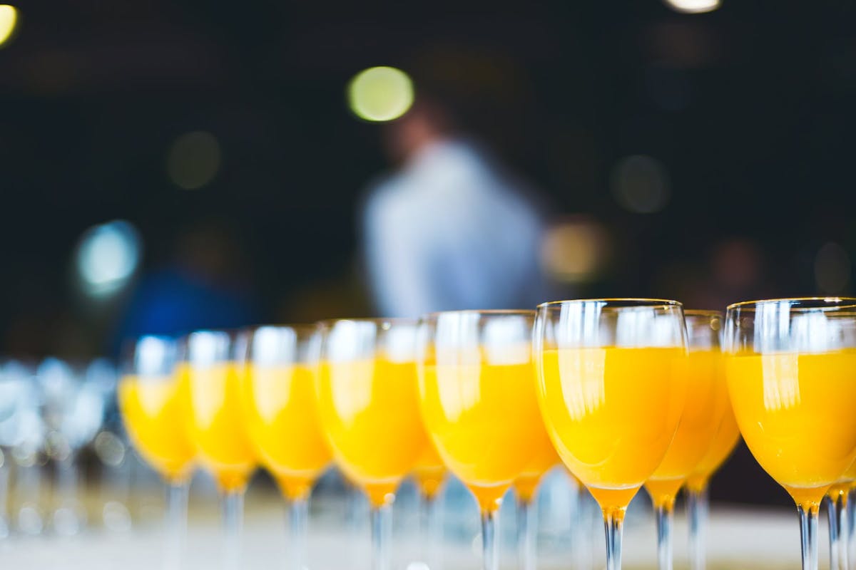glasses of orange juice served on a table