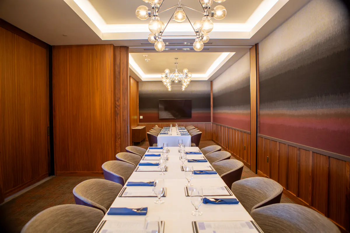 large dining table with white linen and menus