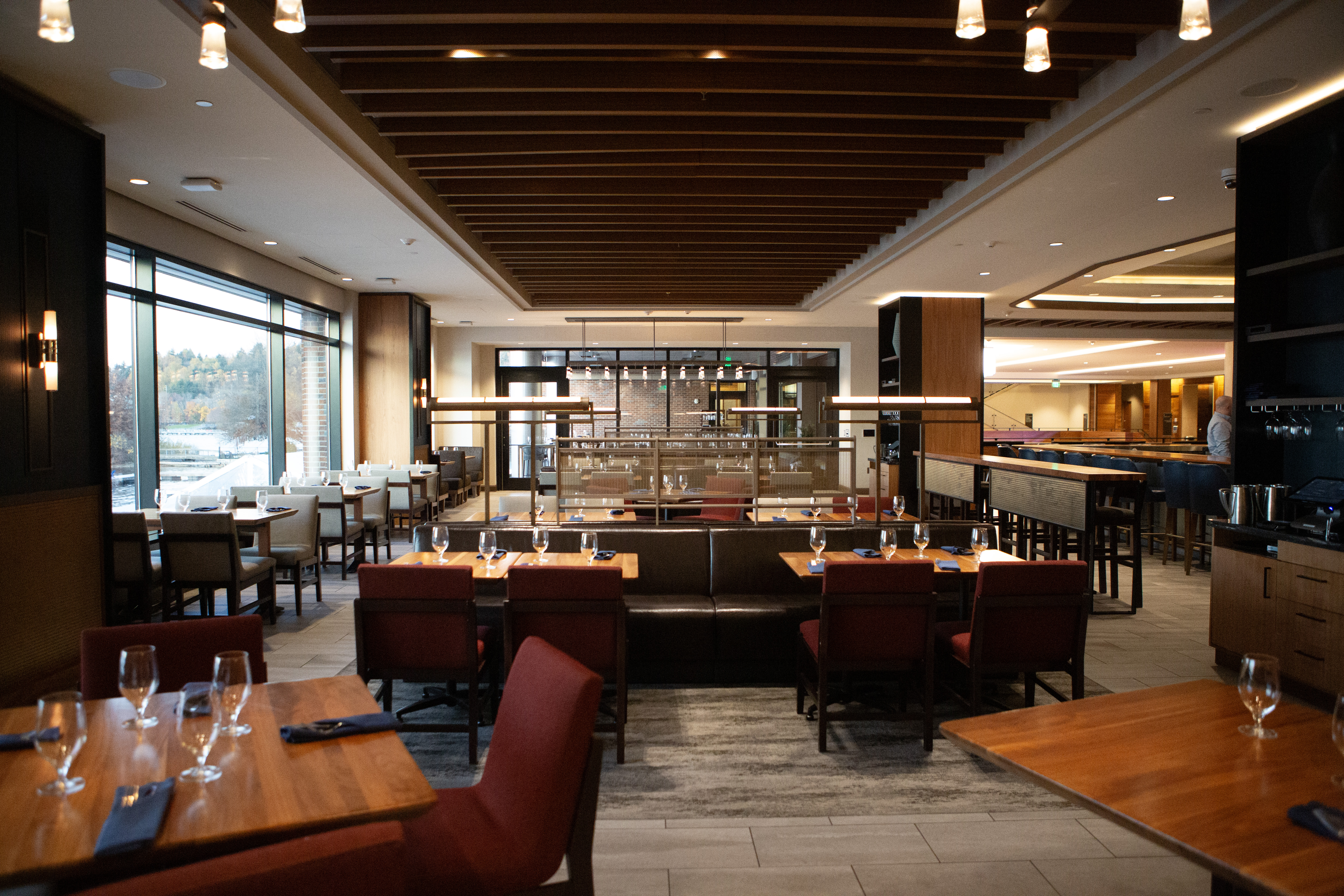 Dining room interior of restaurant. Showing wooden tables and burgundy chairs with open concept.