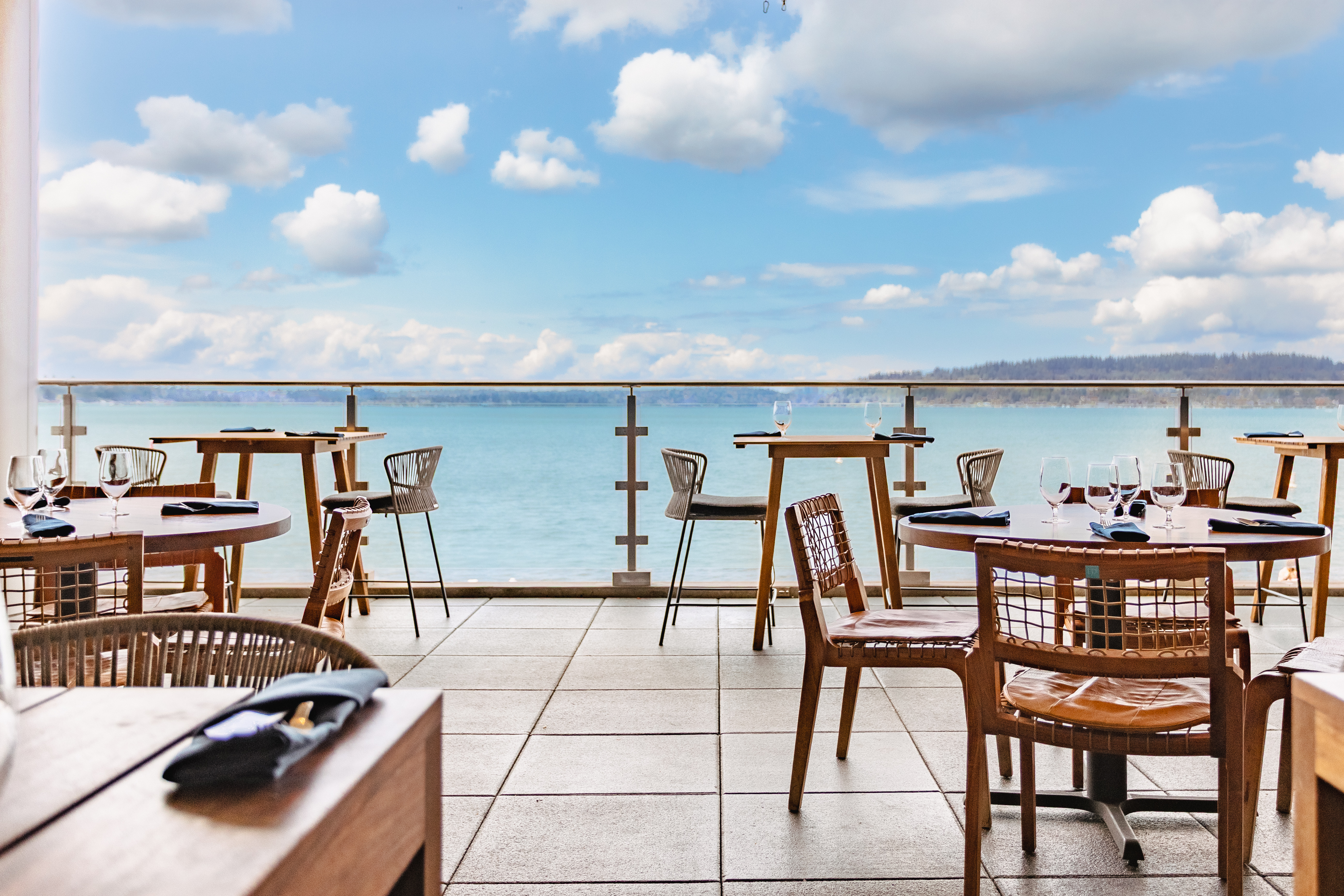 a table and chairs on a patio overlooking a body of water