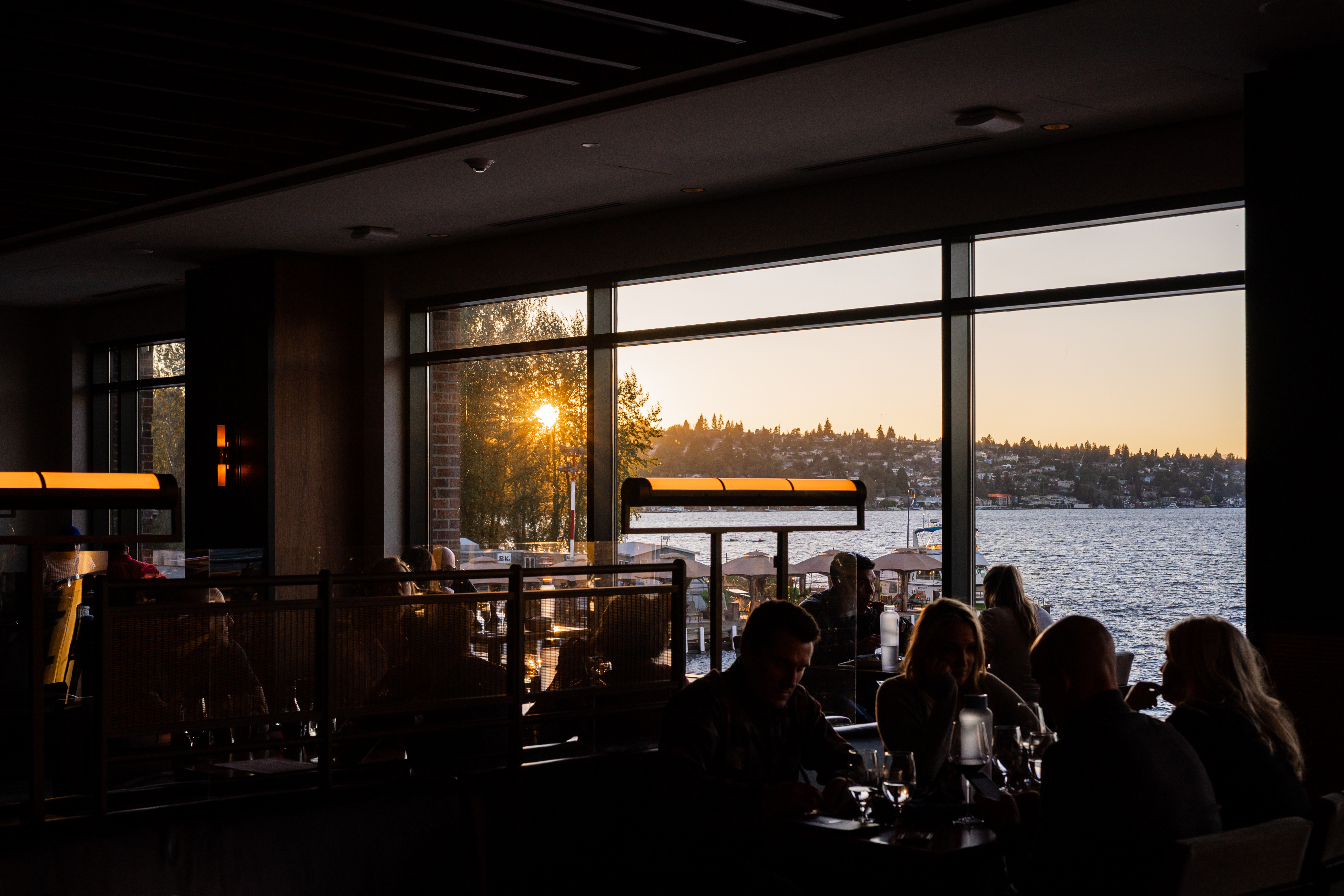 a group of people sitting at a table with a lake in the background