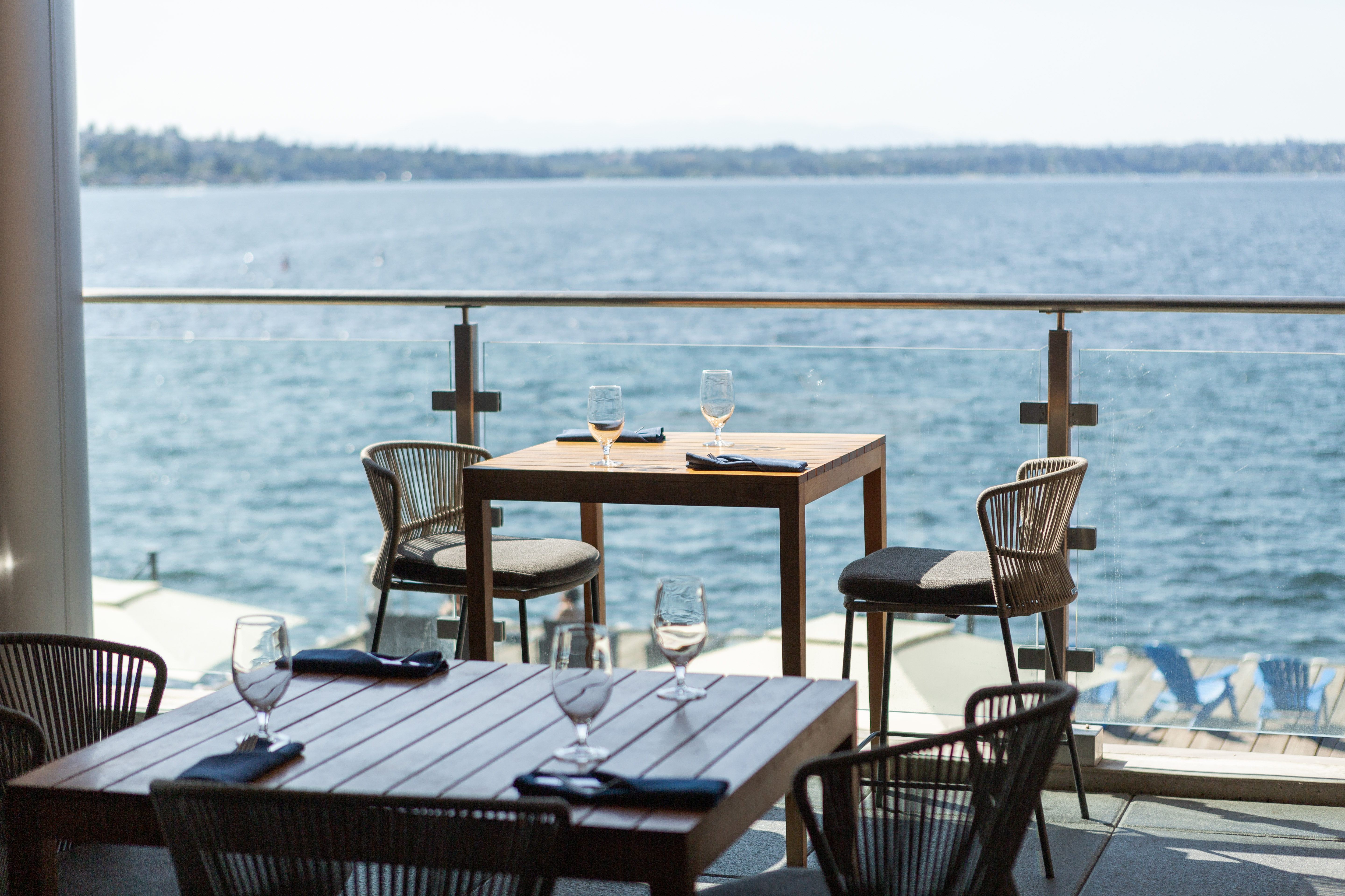 a table and chairs on a deck overlooking a body of water
