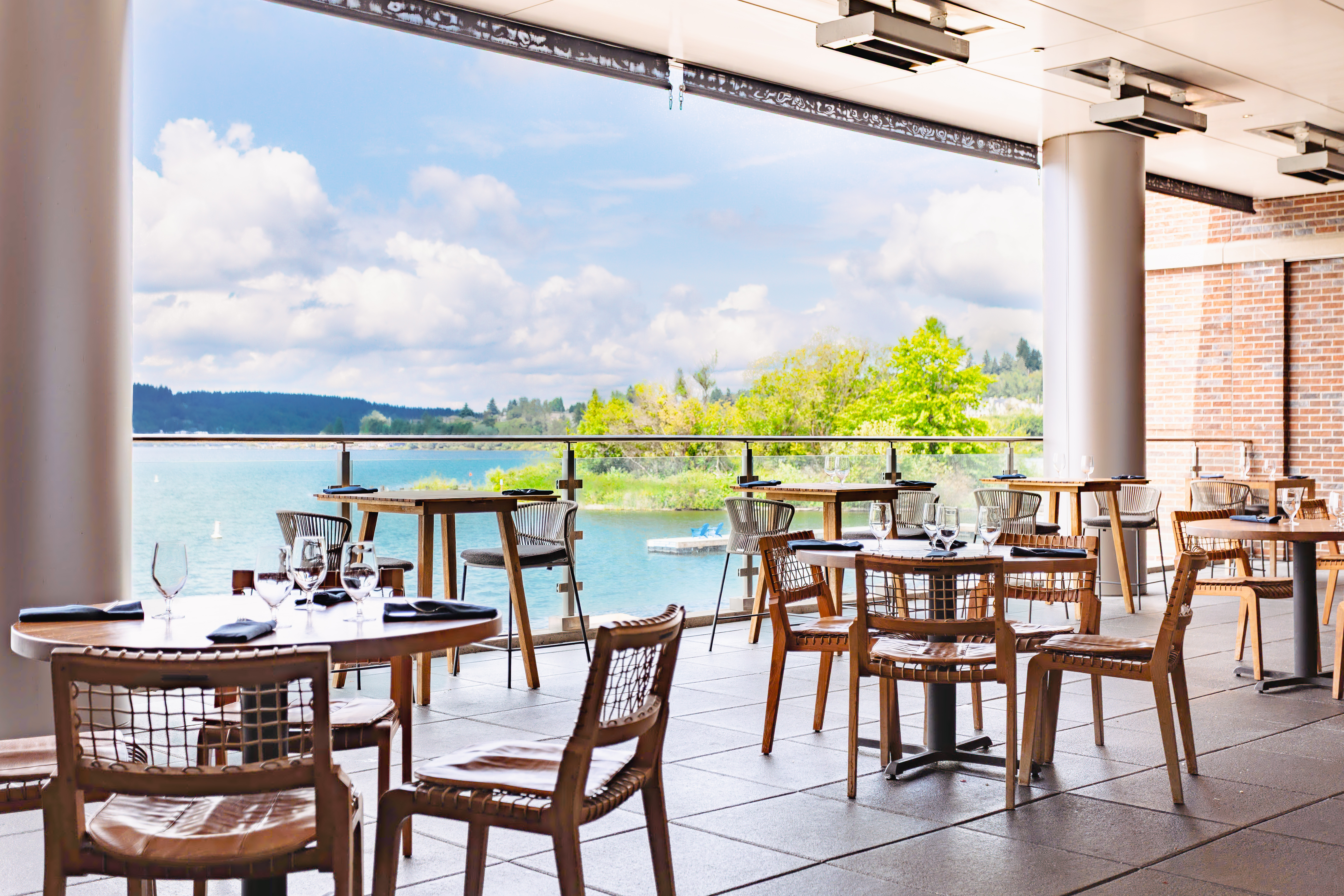 a restaurant with tables and chairs and a body of water
