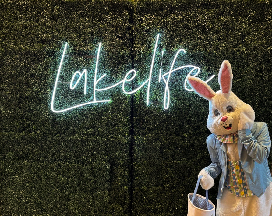 Easter bunny in front of lakelife sign on shrubbery