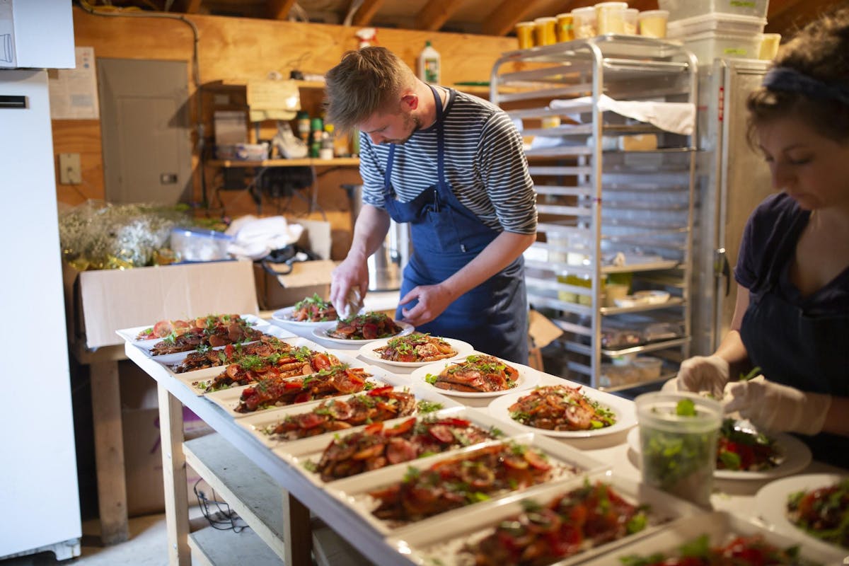 a group of people standing in a kitchen preparing food