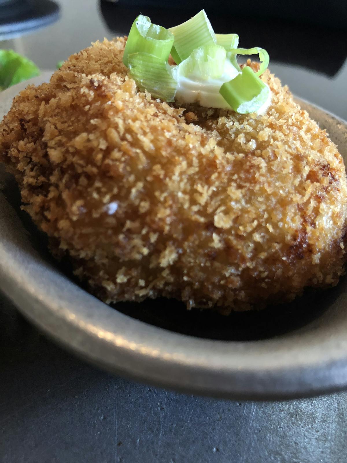 a close up of a potato cake topped with vegetables