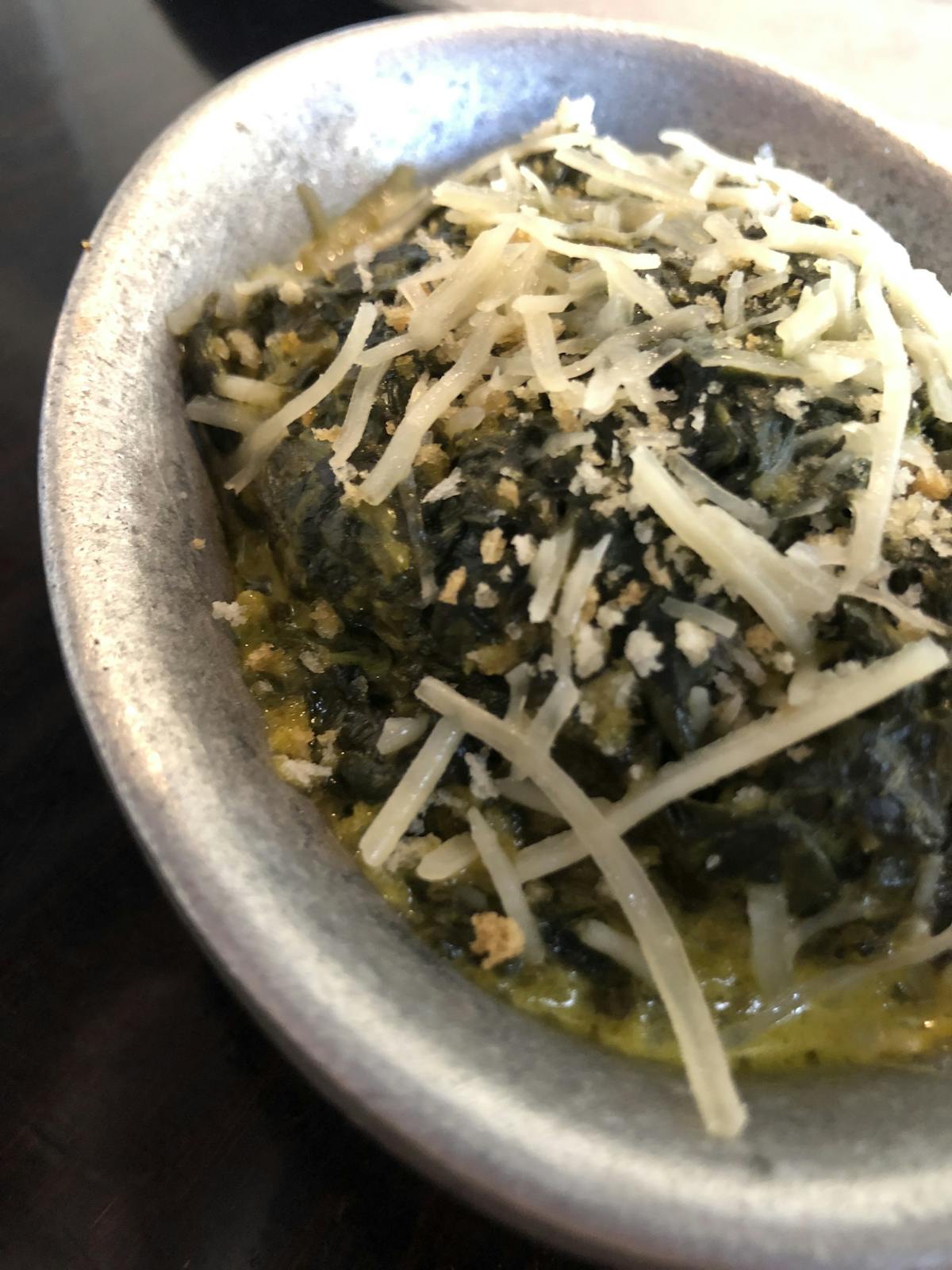 a bowl topped with spinach and chesse