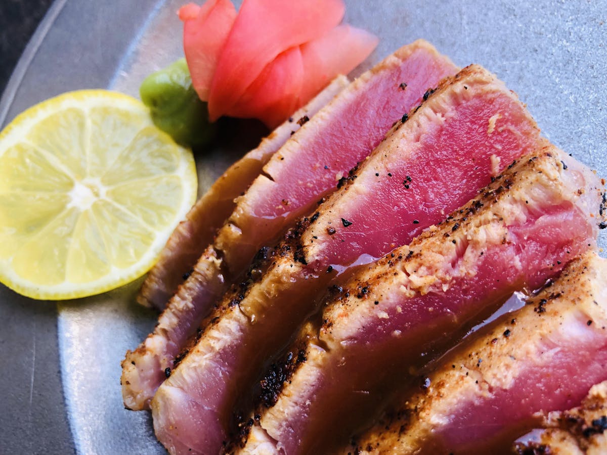 a close up of a cut steak sided by a lemon