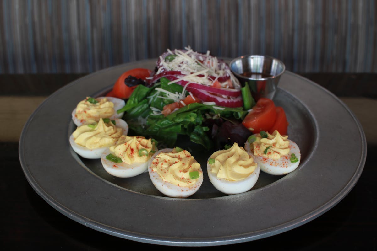 a plate filled with food topped with vegetables