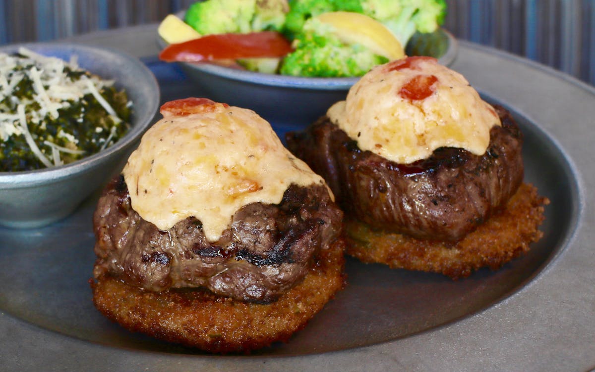 a close up of patties topped with cheese