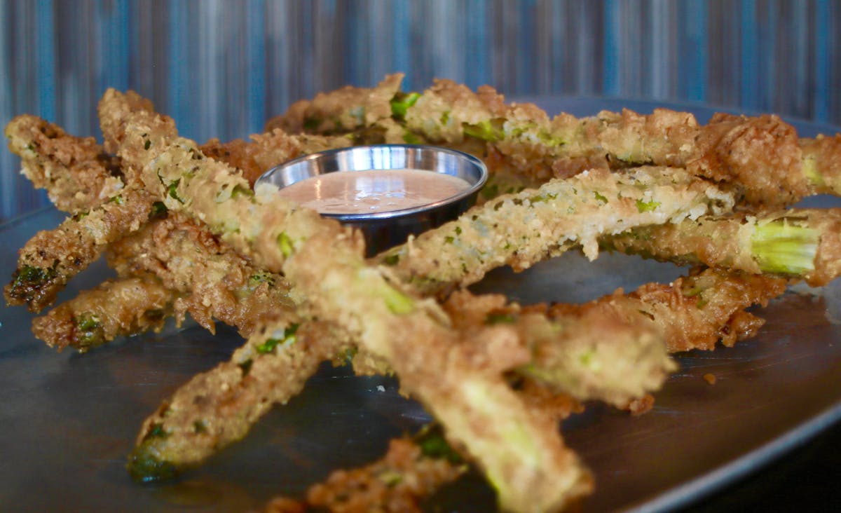 a clse up of a plate with breadsticks sided by a sauce