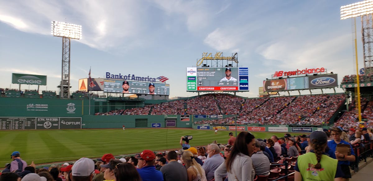 a group of people sitting around a baseball field
