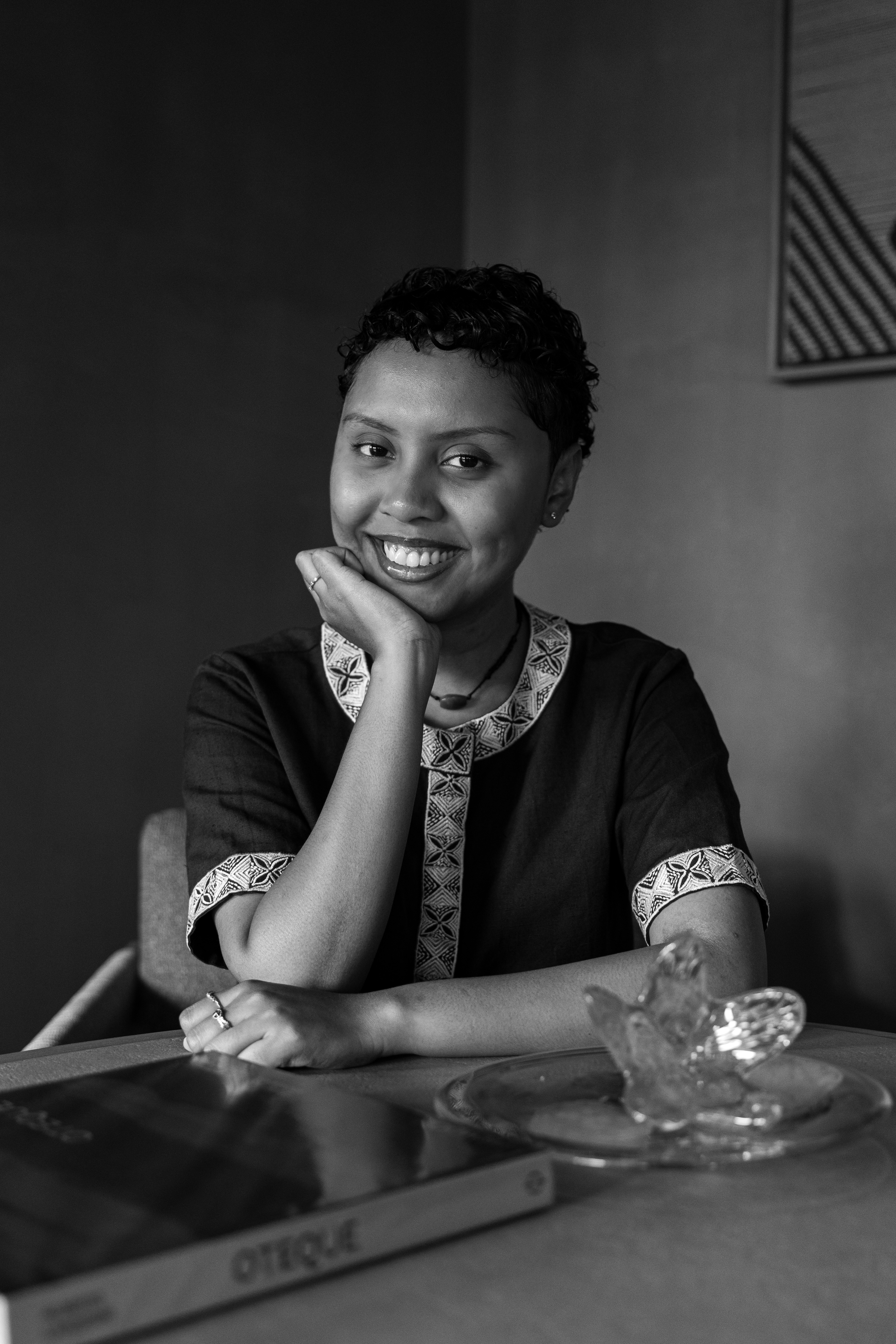 a woman sitting at a table smiling