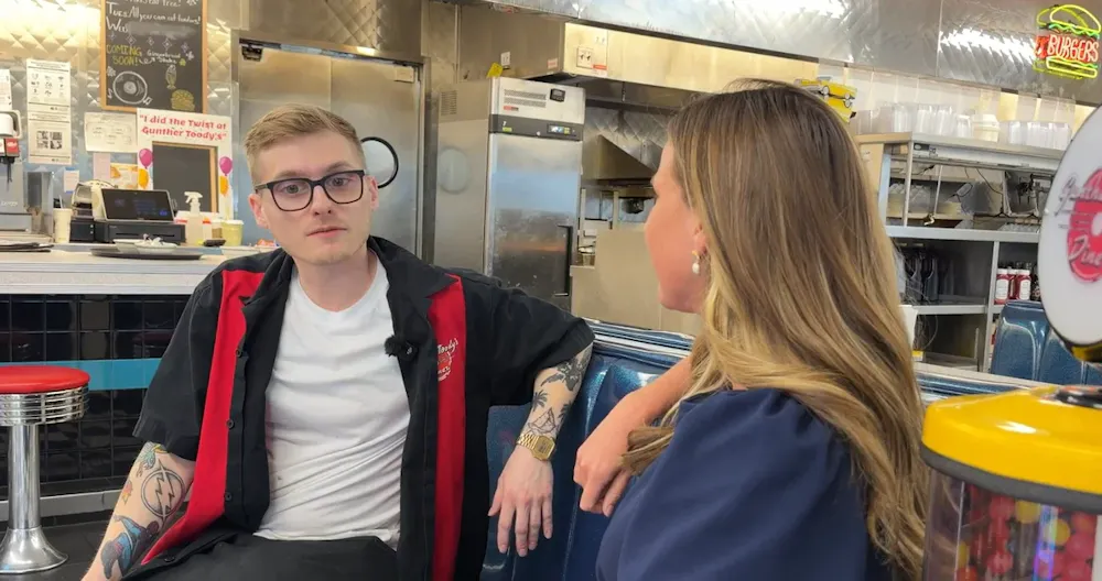 a man and woman sitting in a kitchen