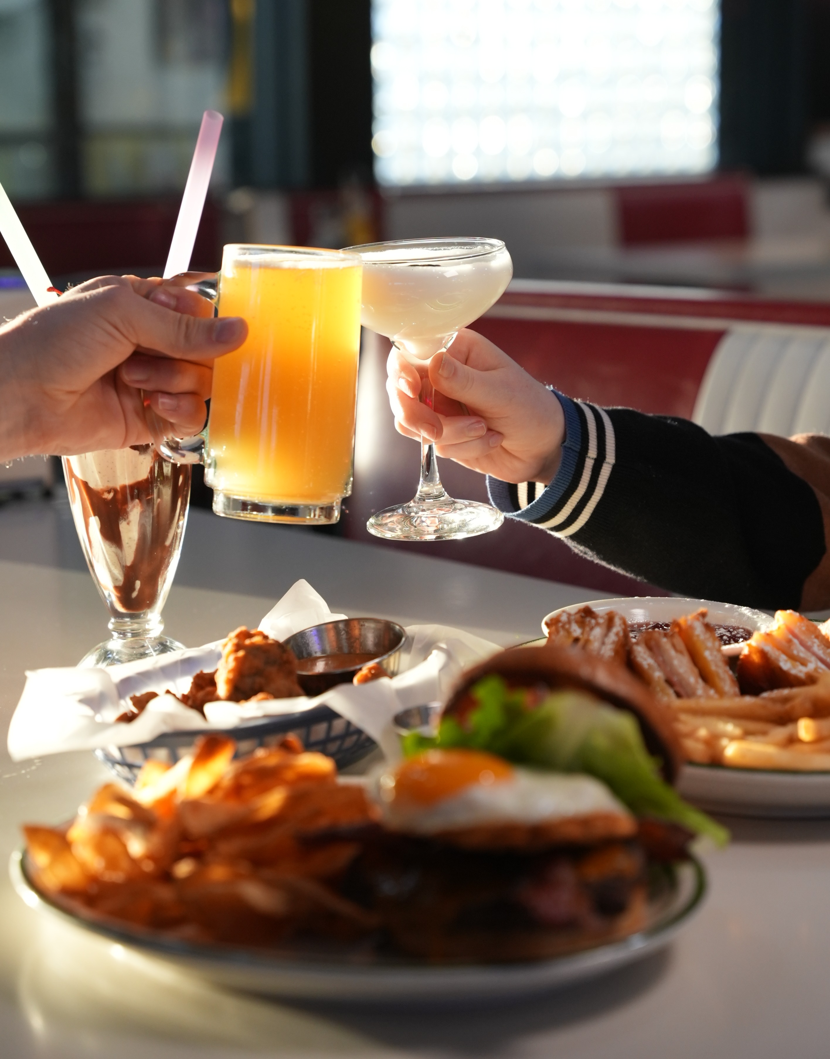 a group of people holding drinks and a plate of food