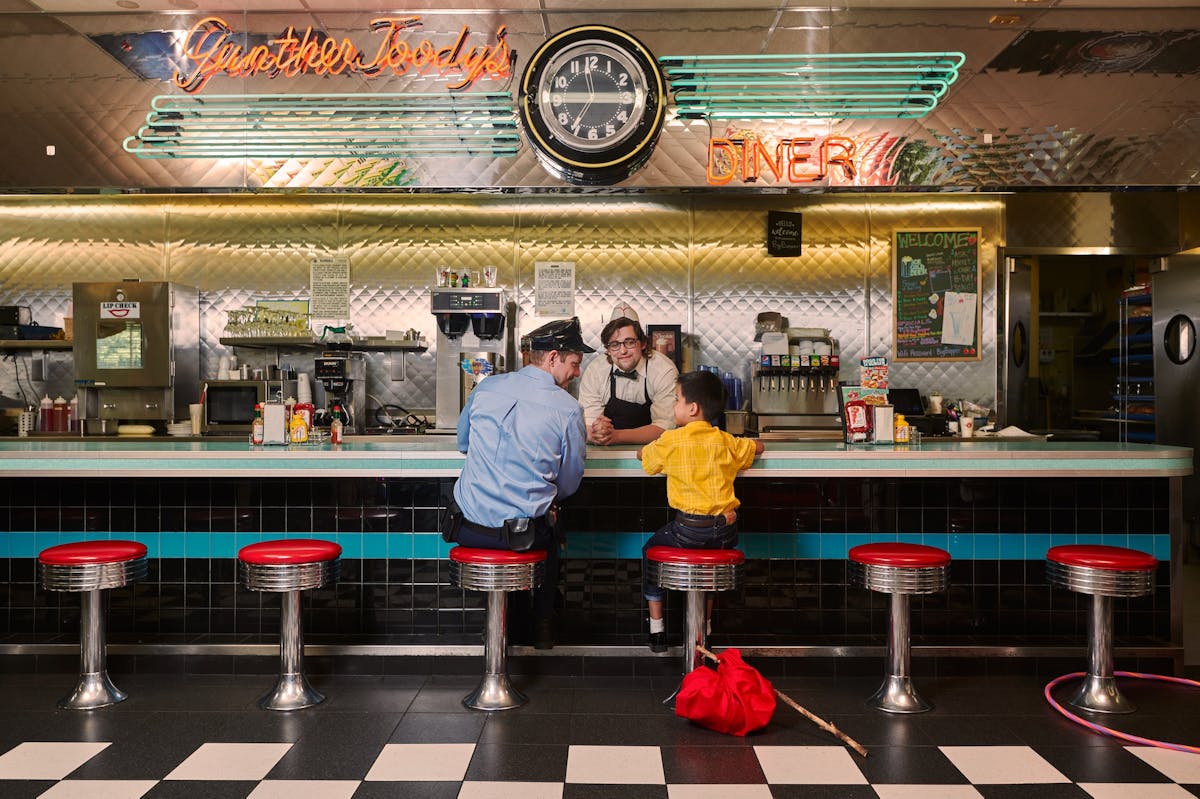 Policeman and child sitting at the diner counter