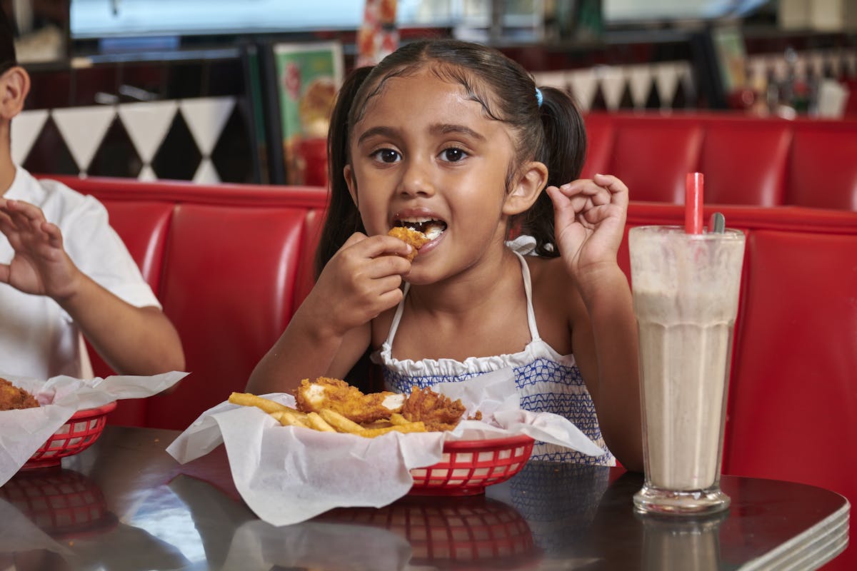 a person sitting at a table eating food