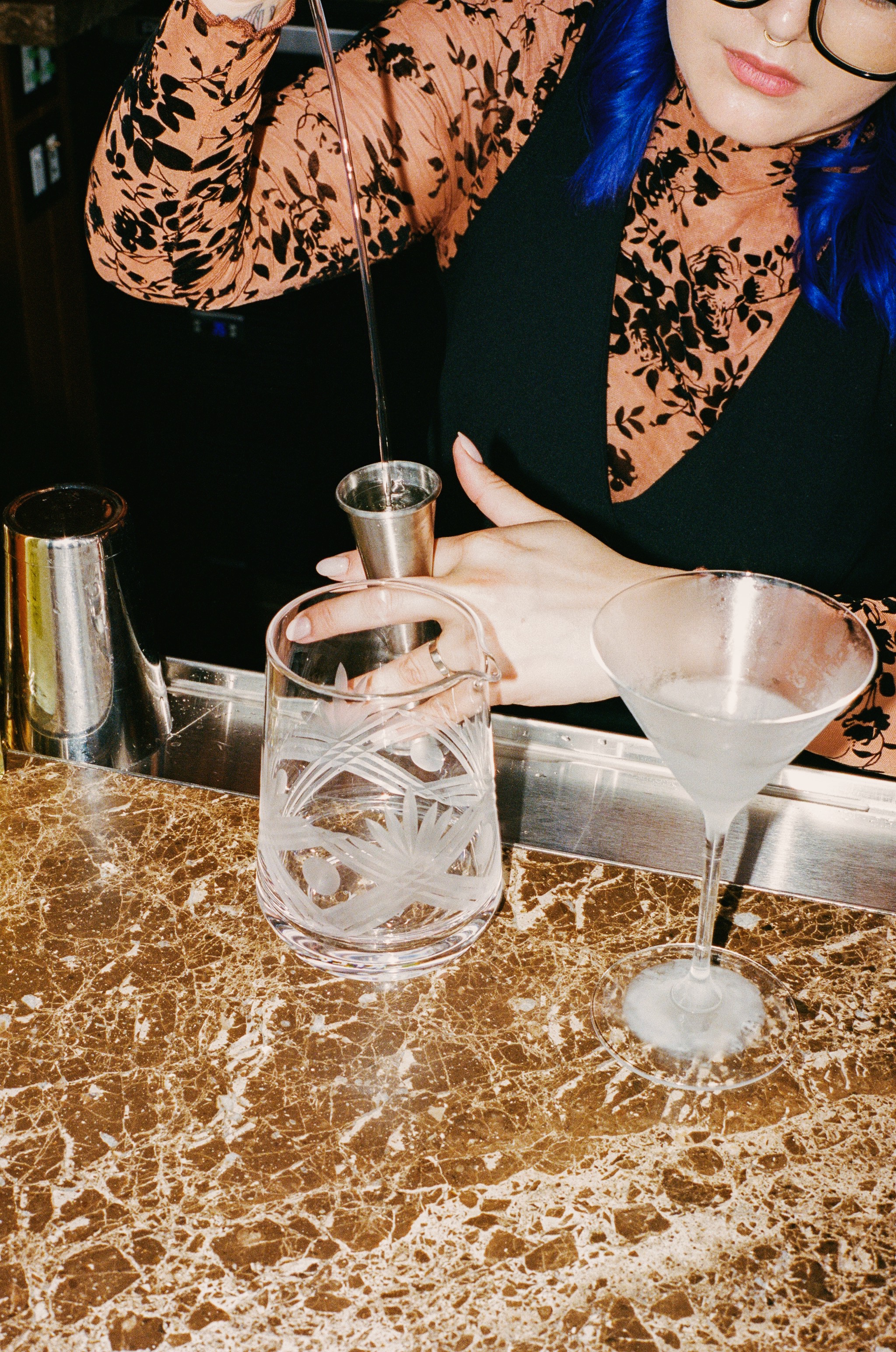 a person pouring a drink into a glass