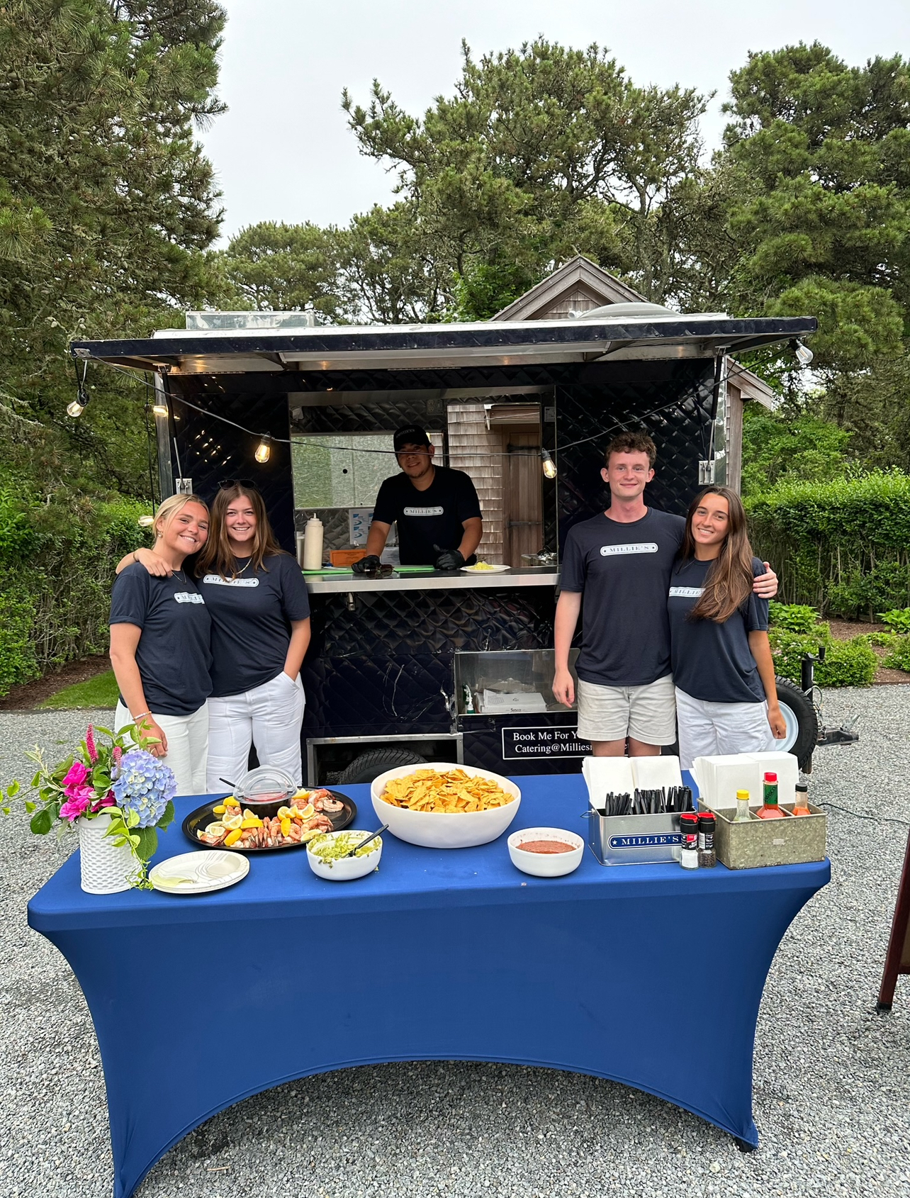 a group of people standing in front of a food truck