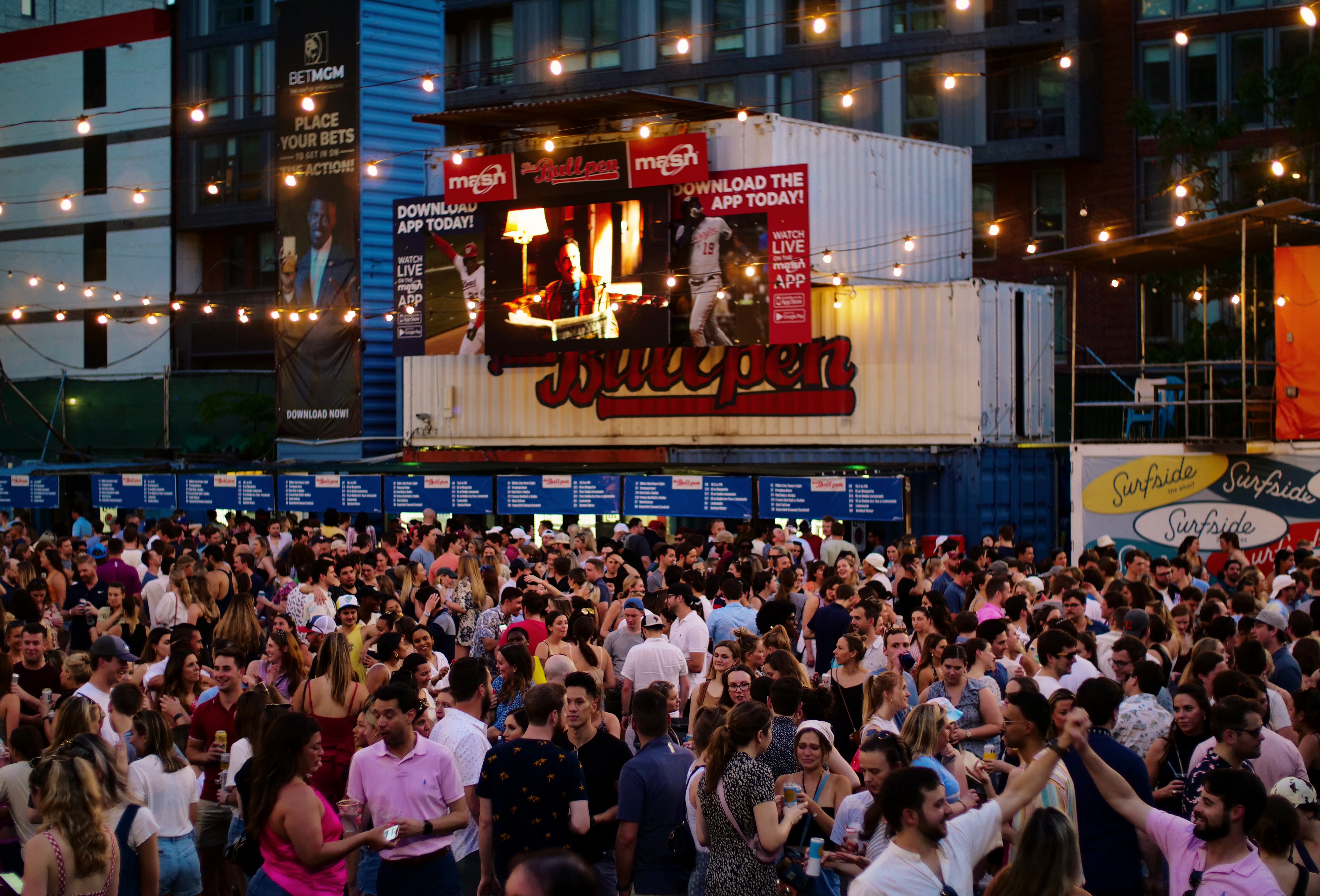 a group of people sitting at a table with a vase of flowers