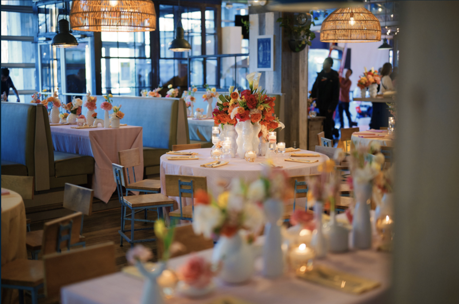 a group of people sitting at a table with a vase of flowers